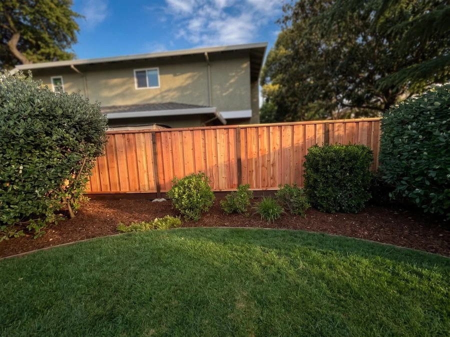 Cedar fence bordering green lawn